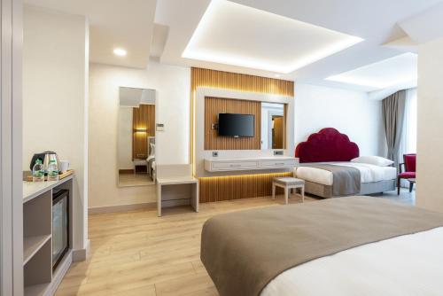 a hotel room with two beds and a flat screen tv at Carina Gold Hotel And Restaurant in Istanbul