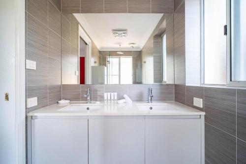 a bathroom with two sinks and a large mirror at The Young - A Peaceful Parkside Delight in Sydney