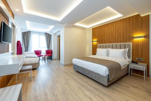 a hotel room with a bed and a desk at Carina Gold Hotel And Restaurant in Istanbul