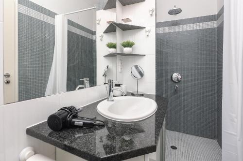 a white bathroom with a sink and a mirror at Apartment FERIA 2 in Opatija