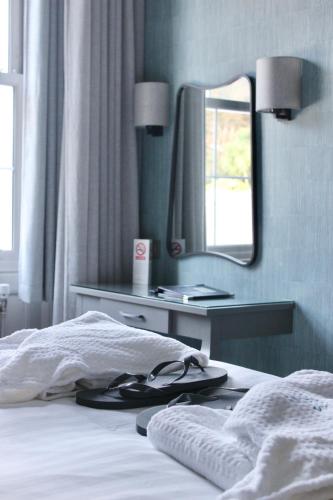 a bedroom with a bed with a mirror on the wall at Lincombe Hall Hotel & Spa - Just for Adults in Torquay