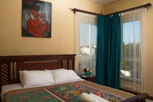 1 dormitorio con 1 cama y una pintura en la pared en Lux Suites Le Royal Apartments Nyali en Mombasa
