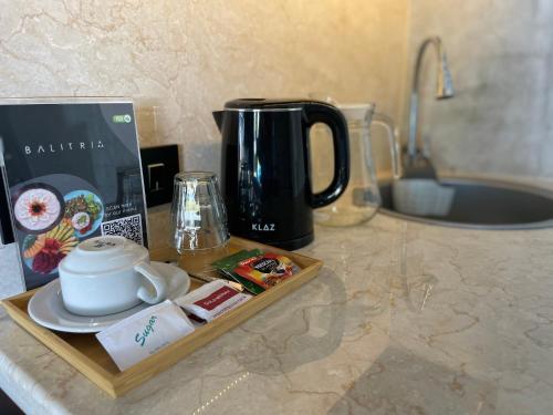 a counter with a tray with a tea pot and a coffee maker at Balitri - hidden gem 9BR service villa hall pool sauna in Sukawati