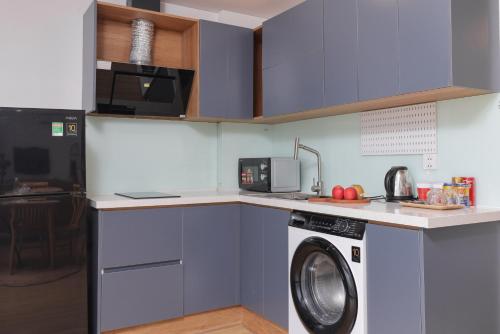 a kitchen with a washing machine and a microwave at LAGOM APARTMENT AND HOTEL in Da Nang