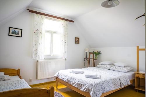 1 dormitorio con 2 camas y ventana en Sioło Budy, en Budy