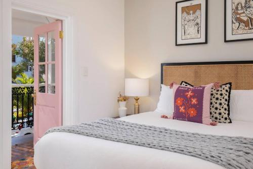 a bedroom with a bed with a pink door at Poolside Glamour - A Stylish Newcastle Hideaway in Newcastle