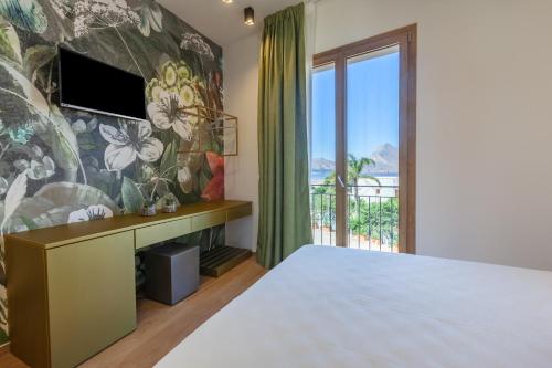 a bedroom with a bed and a wall with a mural at LA DAMA in San Vito lo Capo