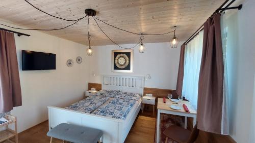 Schlafzimmer mit einem Bett, einem Schreibtisch und einem TV in der Unterkunft Pavlov24 - Domeček u potoka in Pavlov