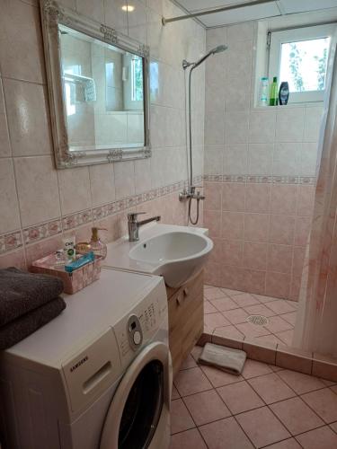 a bathroom with a washing machine and a sink at Pärnu Posti Apartment in Pärnu