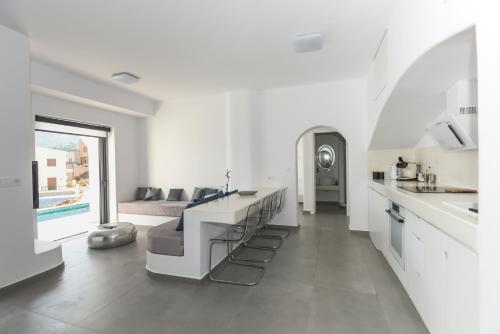 a white kitchen and living room with a couch at Shape-Infinity in Kalymnos