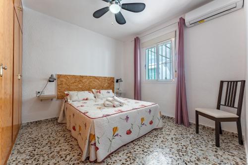 een slaapkamer met een bed en een plafondventilator bij La Casa de los Recuerdos in Málaga