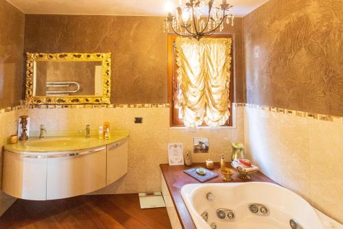 y baño con bañera, lavabo y espejo. en Villa Sasso Il Bianco Varese Lake, en Comerio