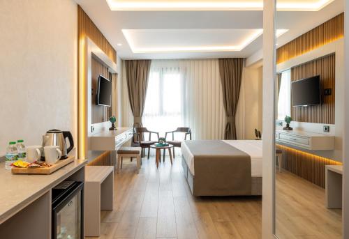 a hotel room with a bed and a kitchen at Carina Gold Hotel And Restaurant in Istanbul