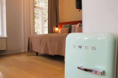 a white refrigerator in a room with a bed at The Folks Hotel Konepaja in Helsinki