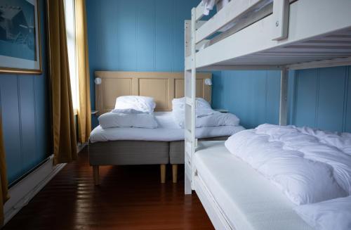 two bunk beds in a room with blue walls at Skanckegårdene AS in Røros