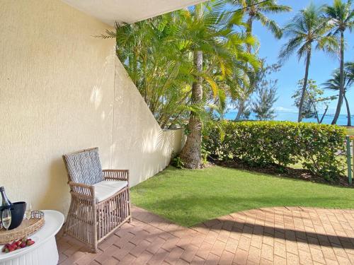 a chair sitting on a patio with palm trees at Sails on Horseshoe Apartment 6 in Horseshoe Bay