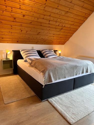 sypialnia z dużym łóżkiem i drewnianym sufitem w obiekcie Ferienwohnung Steinhart Kappel w mieście Lenzkirch