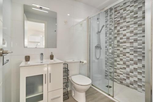 een witte badkamer met een toilet en een douche bij Acapulco Playa 314 in Nerja