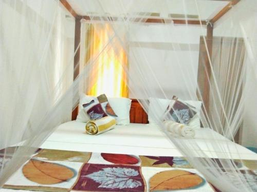a bed in a room with mosquito nets at Hiriketiya Green Hill Home in Dickwella