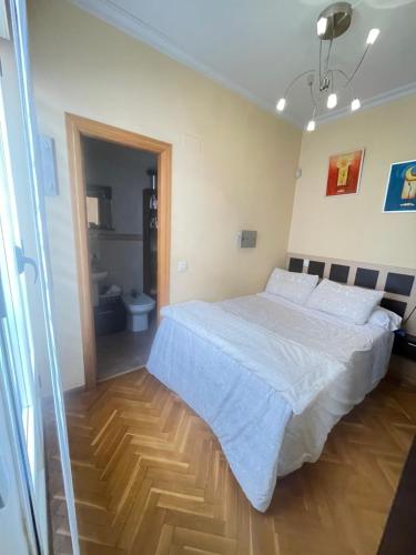 - une chambre avec un grand lit et du parquet dans l'établissement Apartamento nuevo en el centro de Madrid, à Madrid