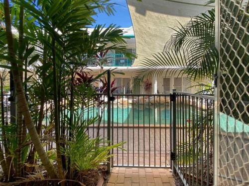 a gate to a house with palm trees and a pool at Sails on Horseshoe Apartment 5 in Horseshoe Bay