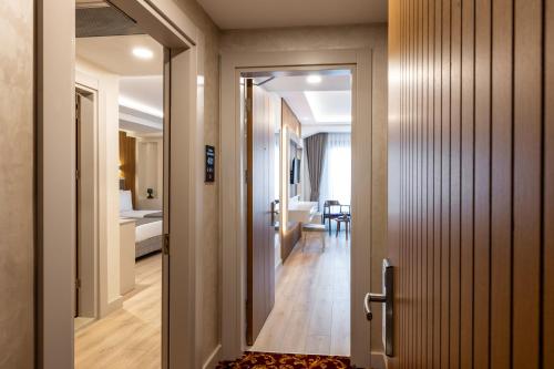 a hallway with a door leading to a bedroom at Carina Gold Hotel And Restaurant in Istanbul