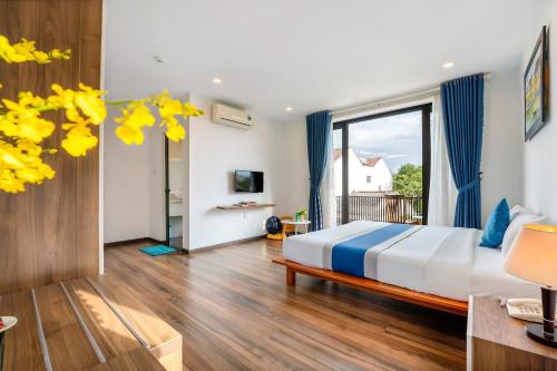 um quarto com uma cama e uma grande janela em Summer holiday villa em Hoi An