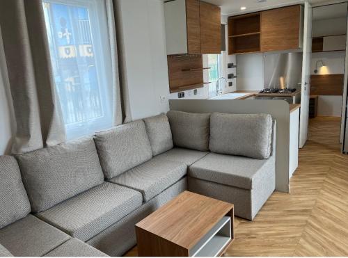 sala de estar con sofá gris y cocina en Luxury Seaside Cottage 28 en Knokke-Heist