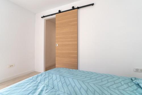 a bed in a room with a sliding door at Maison de pecheur la rose des vents in Valras-Plage