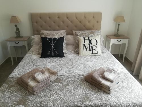 - un lit avec 2 oreillers et des serviettes dans l'établissement Le Mazet d'Olivia, escapade romantique en Provence, à Châteauneuf-de-Gadagne