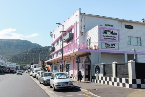 a city street with cars parked in front of buildings at 55 on Main Guesthouse and Spa in Fish hoek