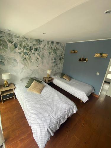 two beds in a room with a wall with plants at Studio 8 in Sancourt