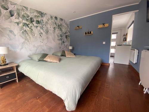 a bedroom with a large white bed with blue walls at Studio 8 in Sancourt