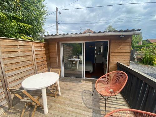 a patio with a table and chairs on a deck at Studio 8 in Sancourt