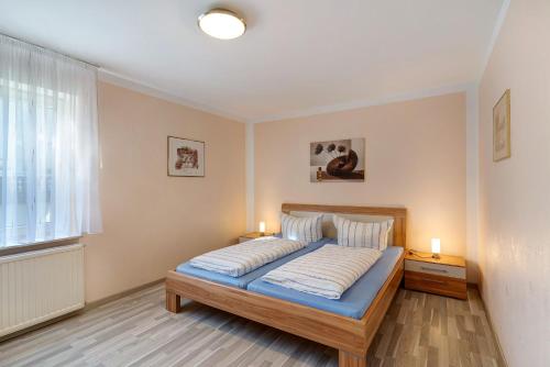 een slaapkamer met een bed met 2 lampen en een raam bij Marliese in Bad Peterstal-Griesbach