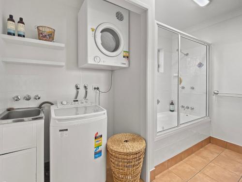 a small kitchen with a sink and a washing machine at Sails on Horseshoe Apartment 4 in Horseshoe Bay