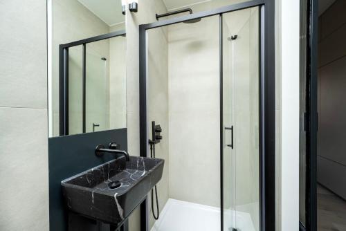 a bathroom with a sink and a glass shower at The Hill by Nestor in Harrow