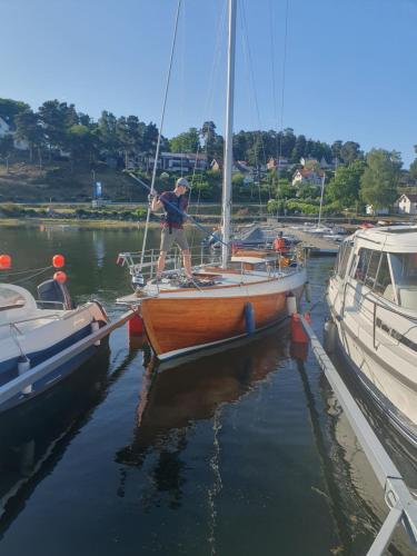 a man standing on a sail boat in the water at Villa Kolmården in Kolmården