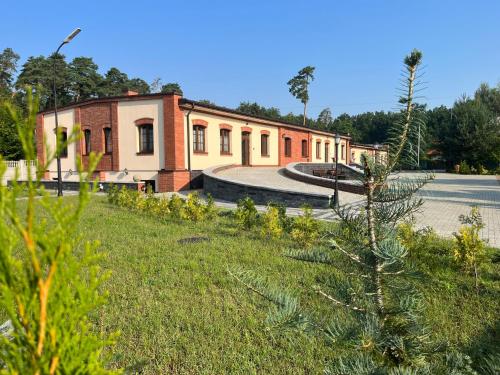a building with a grassy yard in front of a building at Spalskie Pokoje Gościnne in Spała