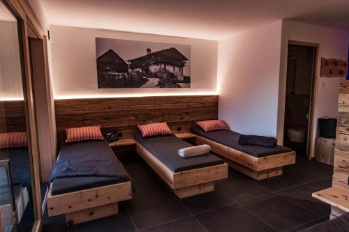 a room with two beds and two ottomans at Kieserhof Apartment Alm in Terento