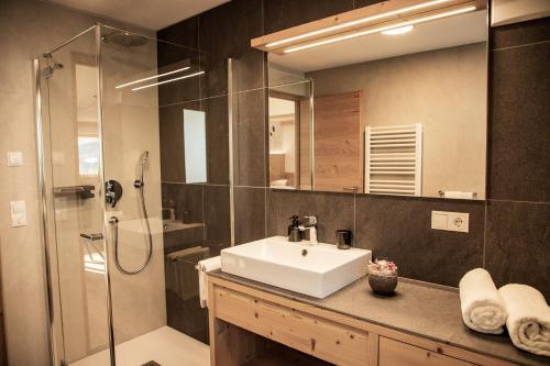 a bathroom with a sink and a shower at Kieserhof Apartment Alm in Terento