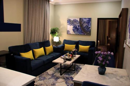 a living room with a blue couch and yellow pillows at شقق سوات للشقق المخدومة 2 in Al Khobar
