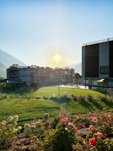 a view of a building and a garden with flowers at Boutique Hotel AMARIL in Castelbello-ciardes