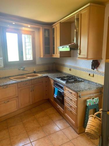 a kitchen with wooden cabinets and a stove top oven at Casa Major in Mont-ral