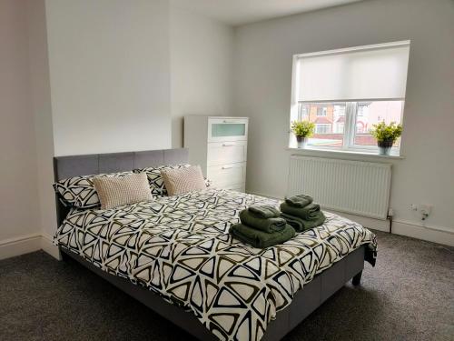 um quarto com uma cama com toalhas verdes em Wentworth Road Accomodation em Doncaster