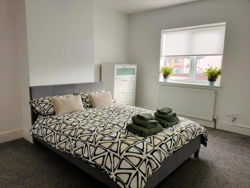 a bedroom with a bed with green towels on it at Wentworth Road Accomodation in Doncaster