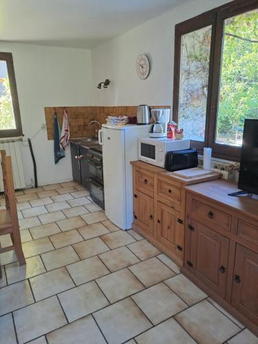 a kitchen with a white refrigerator and a sink at Ferme La Siberie in Entrevaux