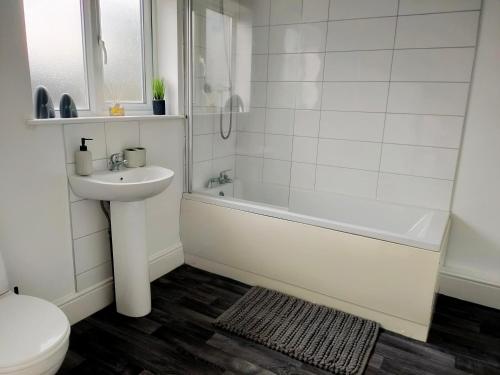 ein Badezimmer mit einem Waschbecken, einer Badewanne und einem WC in der Unterkunft Wentworth Road Accomodation in Doncaster