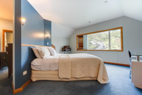 a bedroom with a bed and a window at Bay of Islands Apartment On The Water- The Bridge in Opua