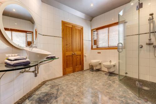 a bathroom with a sink and a toilet and a mirror at Bay of Islands Apartment On The Water- The Bridge in Opua